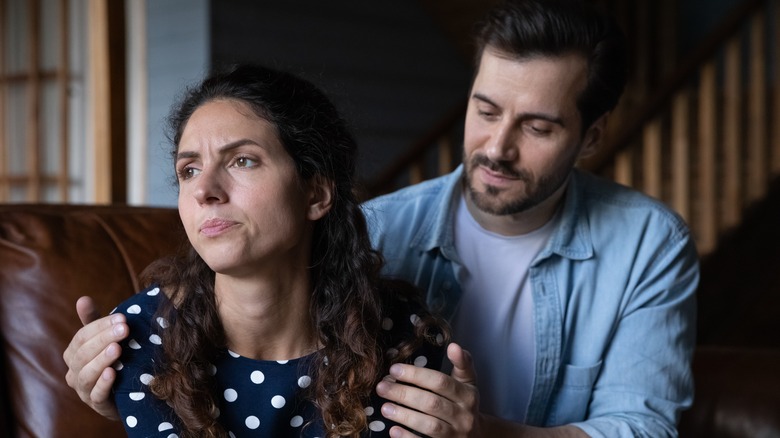 Man touching annoyed woman