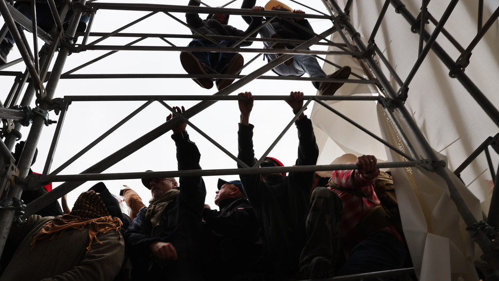 Trump supporters climbing scaffolding