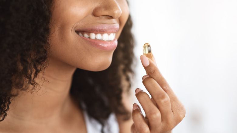 woman smiling taking hair supplement
