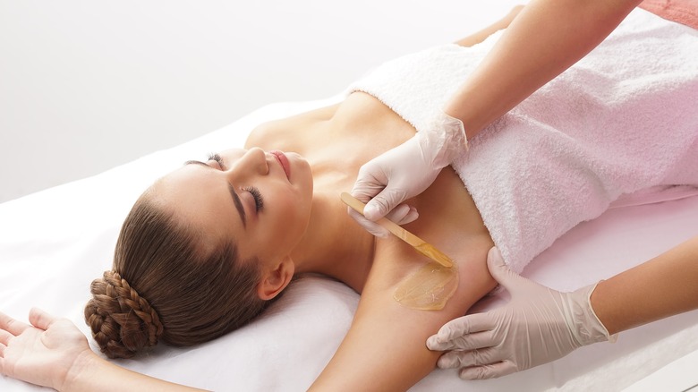 woman having her underarms waxed