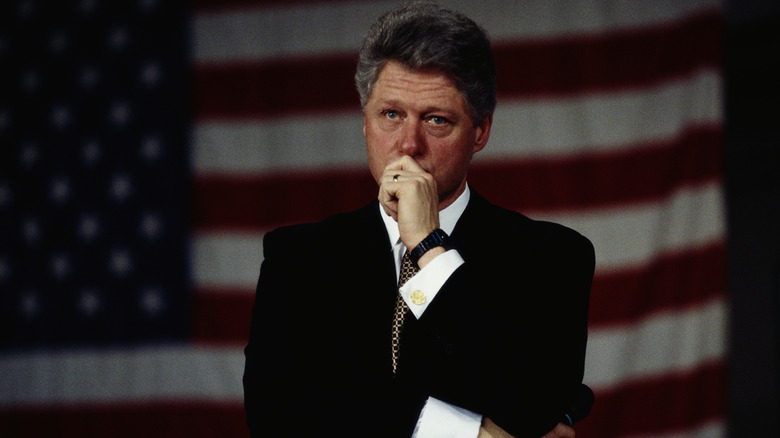 Bill Clinton, while president, stands in front of a large American flag