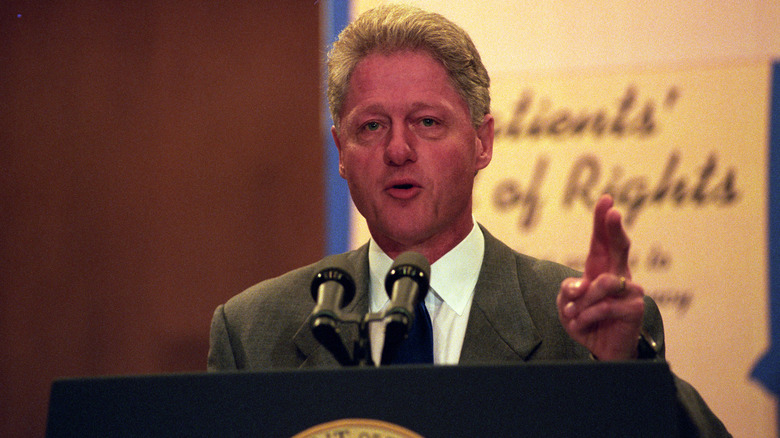 Bill Clinton speaks from a lectern in 1998