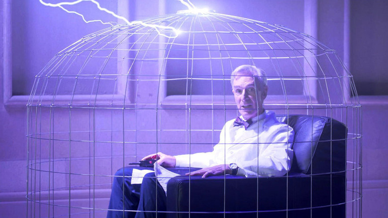 Bill Nye sitting in a cage in The End is Nye