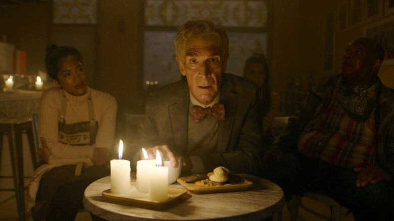 Bill Nye sitting at a table with candles in The End is Nye