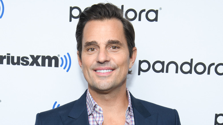 Bill Rancic smiling in a dark blazer 