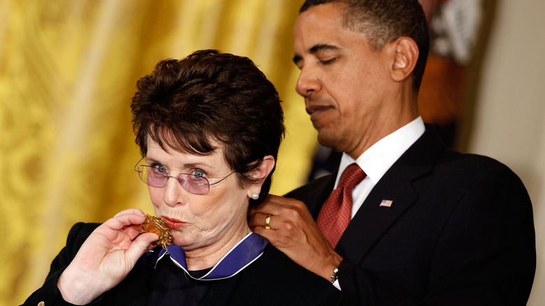 Billie Jean King kisses Presidential Medal of Freedom while President Obama fastens it around her neck