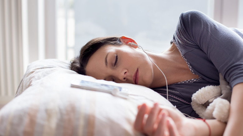 Woman sleeping with earphones on