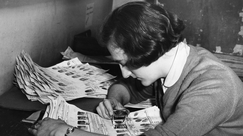 woman studying fingerprints, 1950s