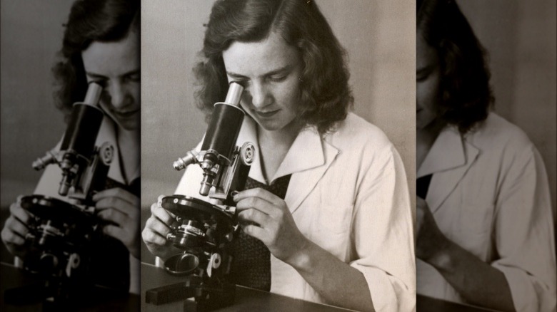 Woman looking into a microscope, 1955