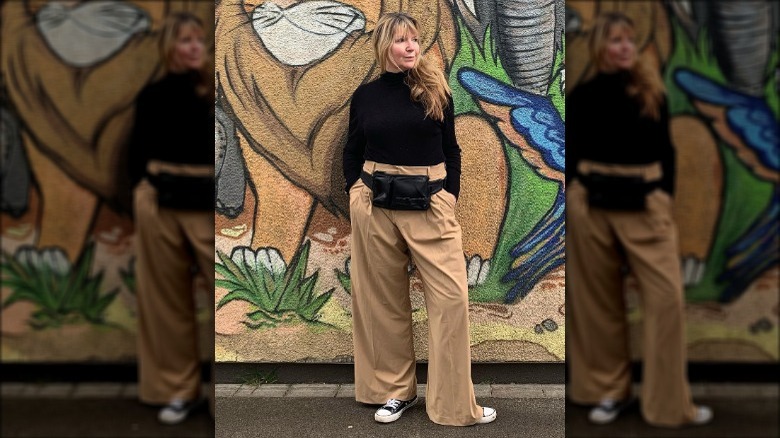 woman posing by mural