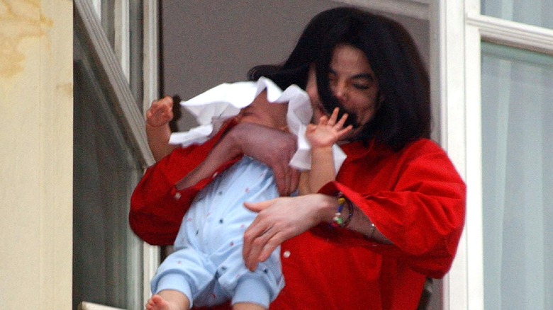 Michael Jackson dangling Blanket Jackson off a balcony