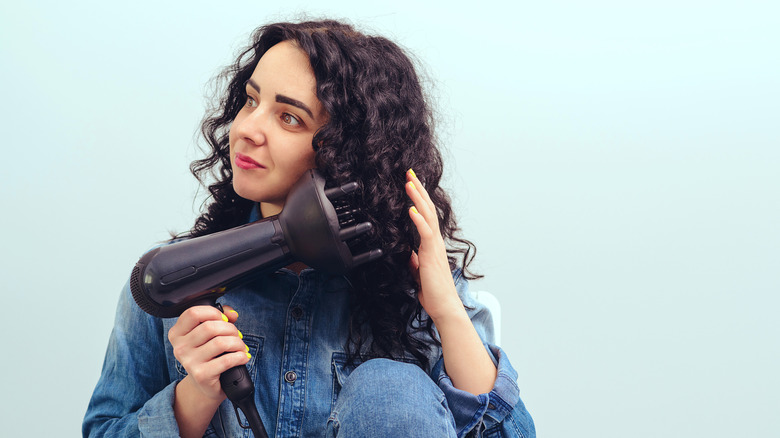 Woman blow drying hair with diffuser