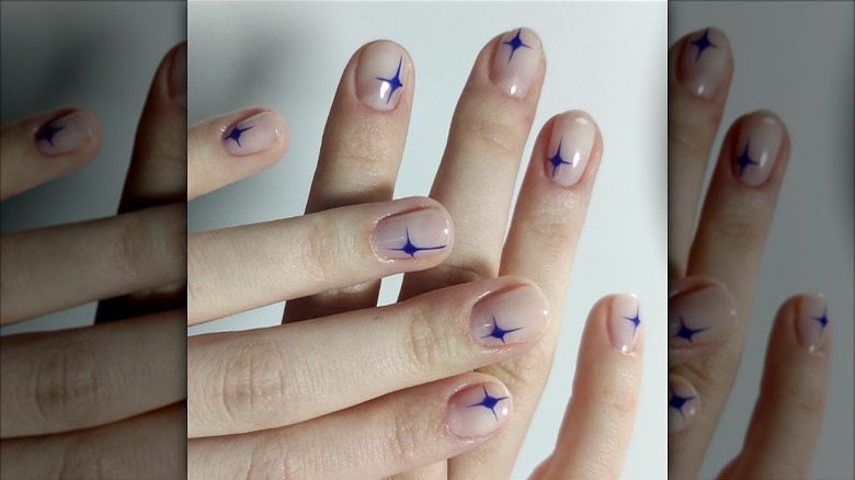 blue star shapes on clear-polished nails