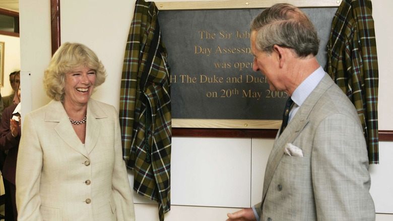 Queen Camilla and King Charles laughing during event in 2000s