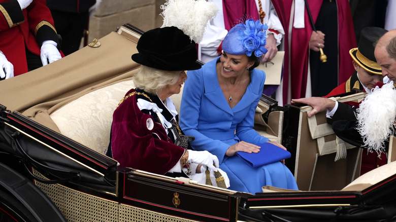 Camilla and Catherine chat and smile in a carriage 