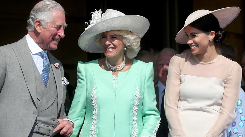 Charles, Camilla, and Meghan Markle smile while gathering together 