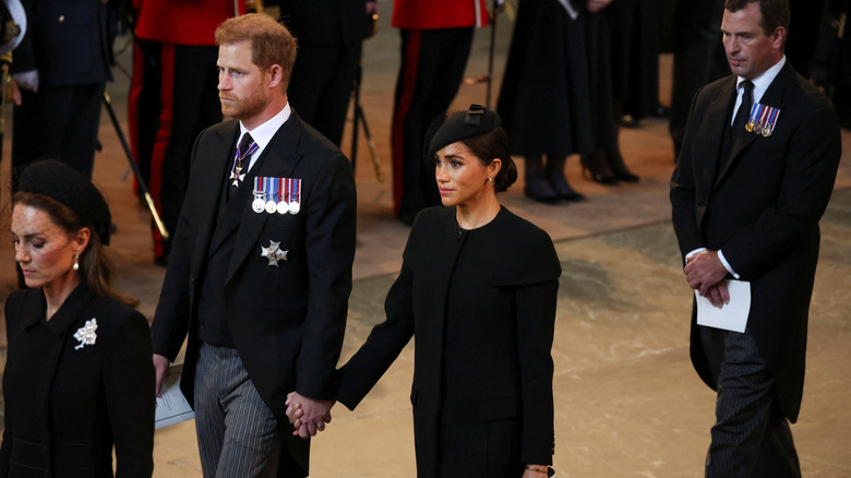 Prince Harry and Meghan Markle hold hands