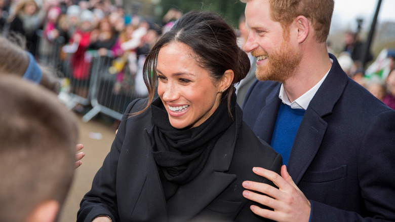 Prince Harry with his hand on Meghan Markle