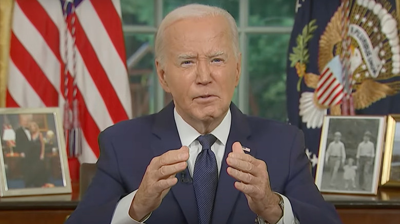 President Biden raising hands during speech