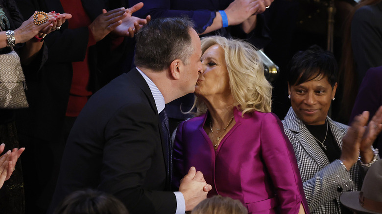 Second gentleman Doug Emhoff (L) and First Lady Jill Biden greet each other with kiss as she arrives for U.S. President Joe Biden's State of the Union 