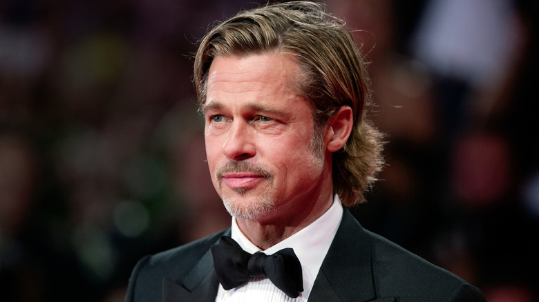 Brad Pitt posing on red carpet in a black suit