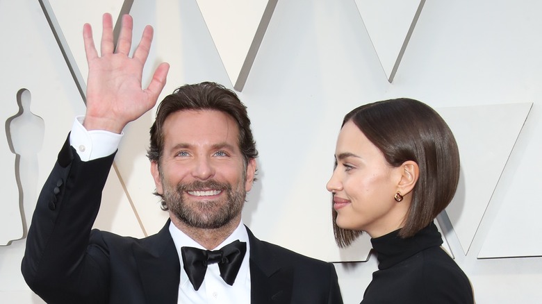 Bradley Cooper waving while Irina Shayk looks at him