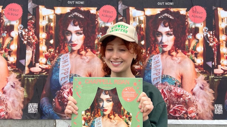 Chappell Roan smiling, holding vinyl record