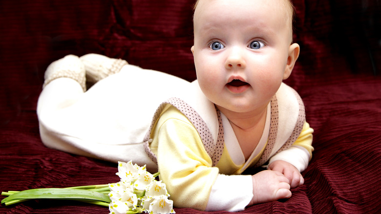 baby next to flowers