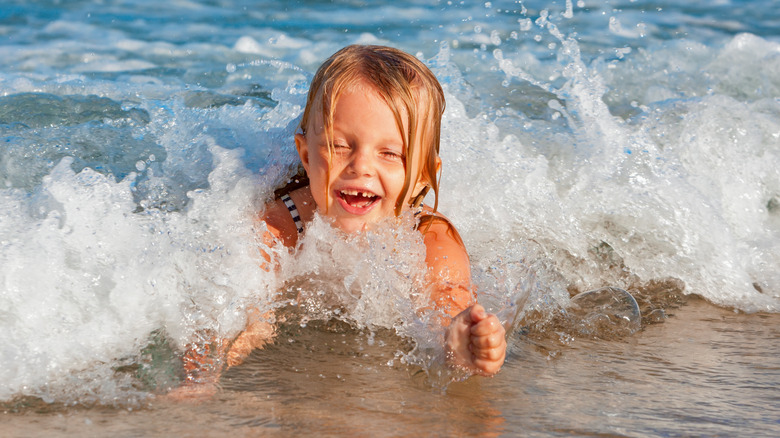 baby playing in ocean