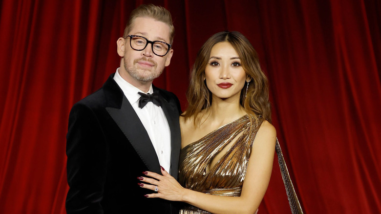 Macaulay Culkin arm around Brenda Song in formal wear