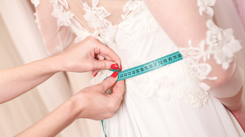 hands measuring wedding gown