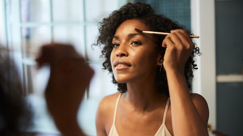 Woman using brush on her eyebrows