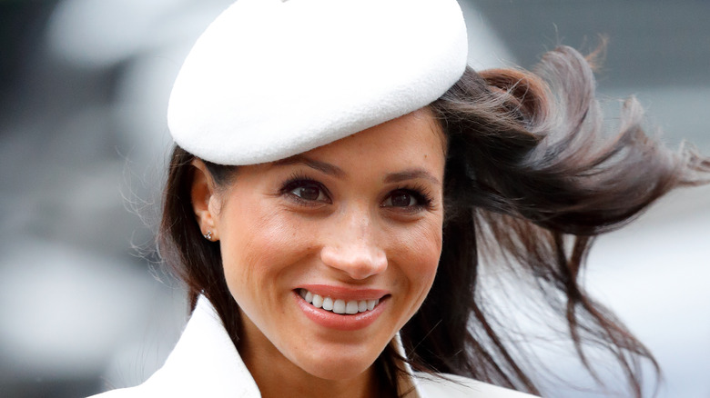 Meghan Markle wearing white hat and jacket