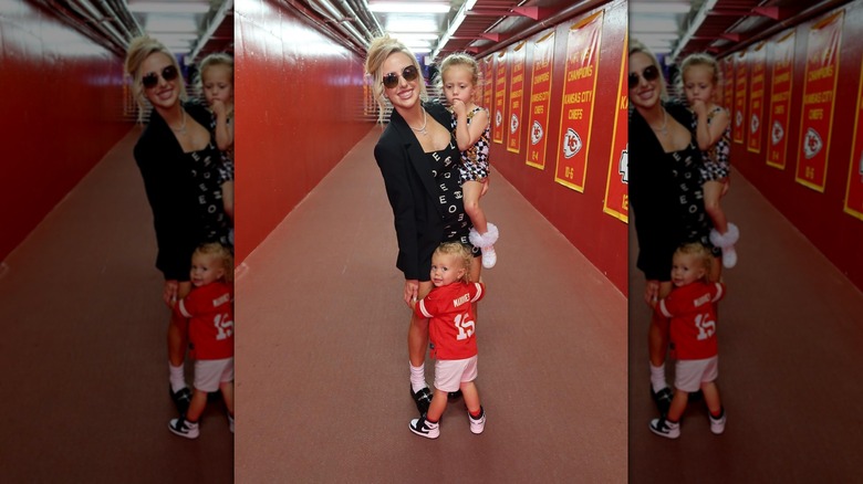 Brittany Mahomes posing with her children in stadium corridor