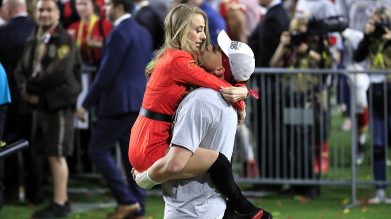 Patrick Mahomes carrying Brittany Mahomes