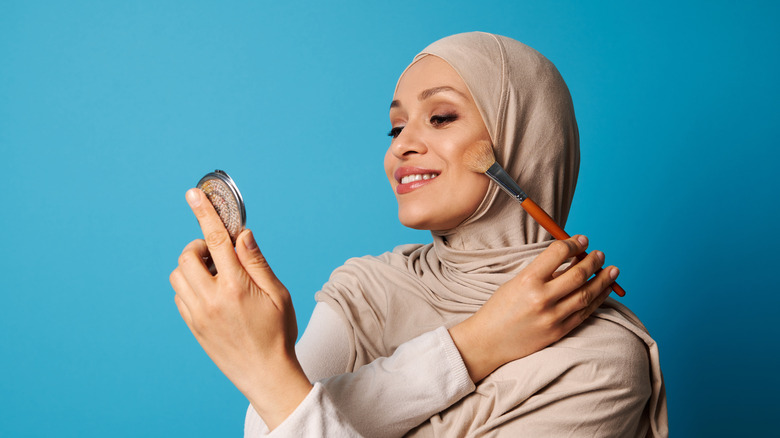 woman applying bronzer