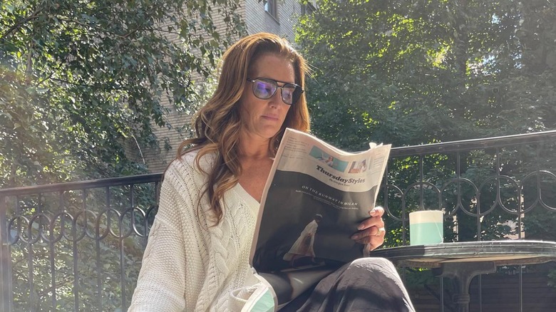 Brooke Shields reading newspaper at home