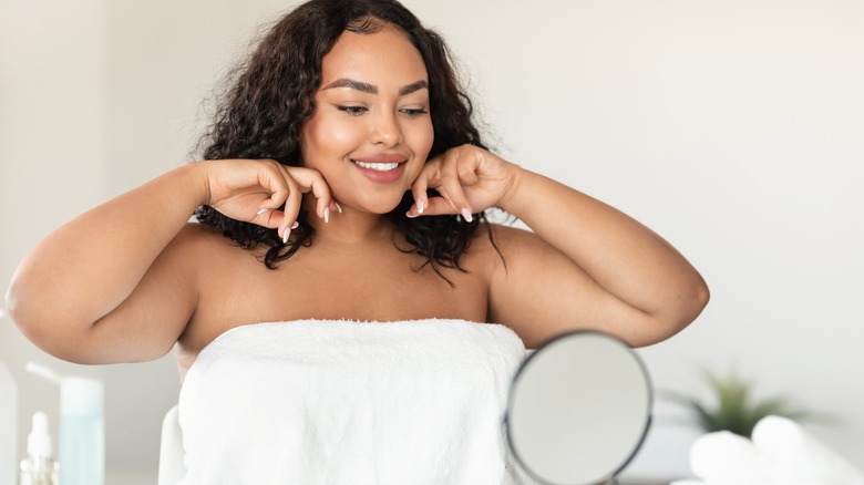 woman doing skincare in mirror