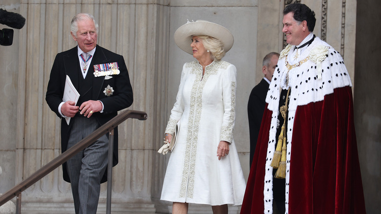 Camilla, Queen Consort walking with King Charles III and a clergyman