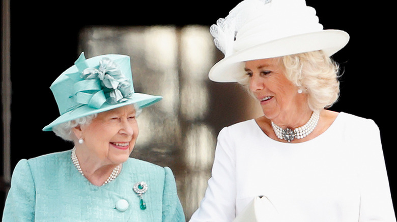 Queen Elizabeth and Camilla Parker Bowles smiling and talking