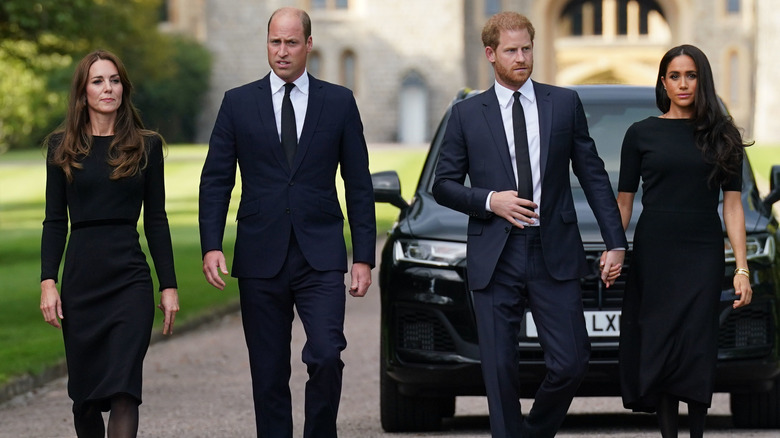 Catherine Middleton, Prince William, Prince Harry and Meghan Markle walking to greet mourners at Windsor Castle