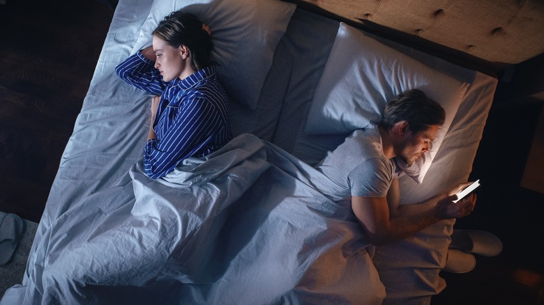 A couple in bed facing away from each other