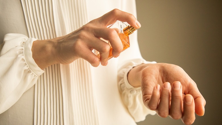 Woman putting on perfume