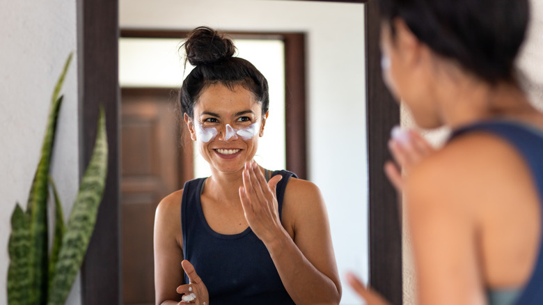 woman applying sunscreen to face