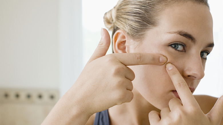 Woman poking at her face