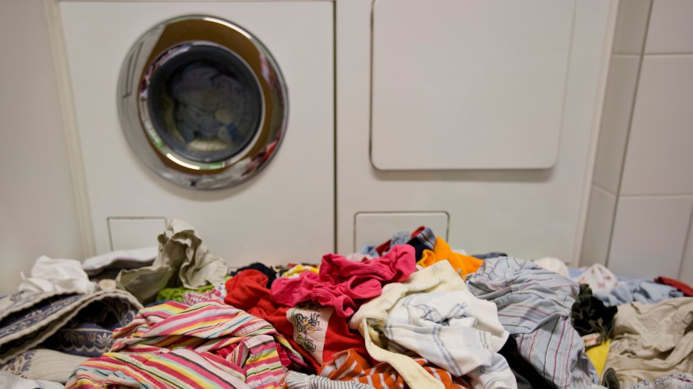 dirty laundry in front of washing machine