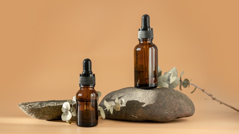 essential oil bottles with stones and flowers