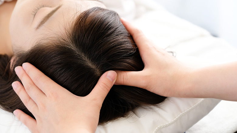 A woman getting a scalp massage