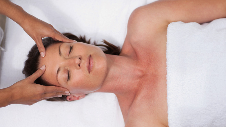 A woman receiving a facial massage 