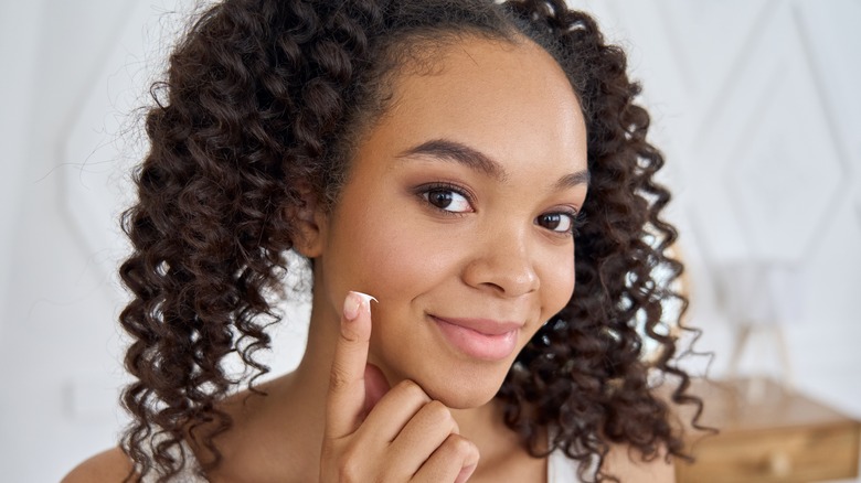 smiling woman with skincare cream
